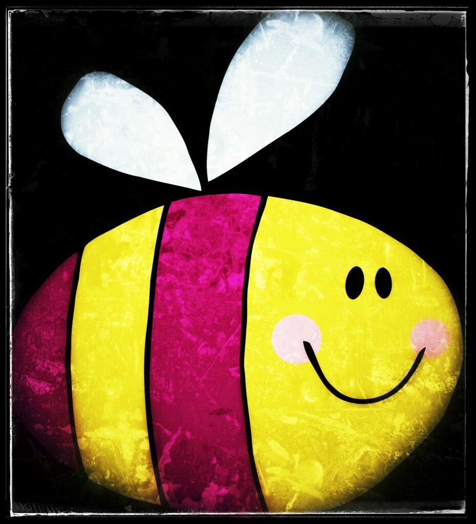 A picture of a cartoon, egg-shaped bee with purple-magenta stripes on its yellow body. It has two black dots for eyes, a big, smiling mouth, and rosy pink cheeks. It's borne aloft on two tiny white wings.